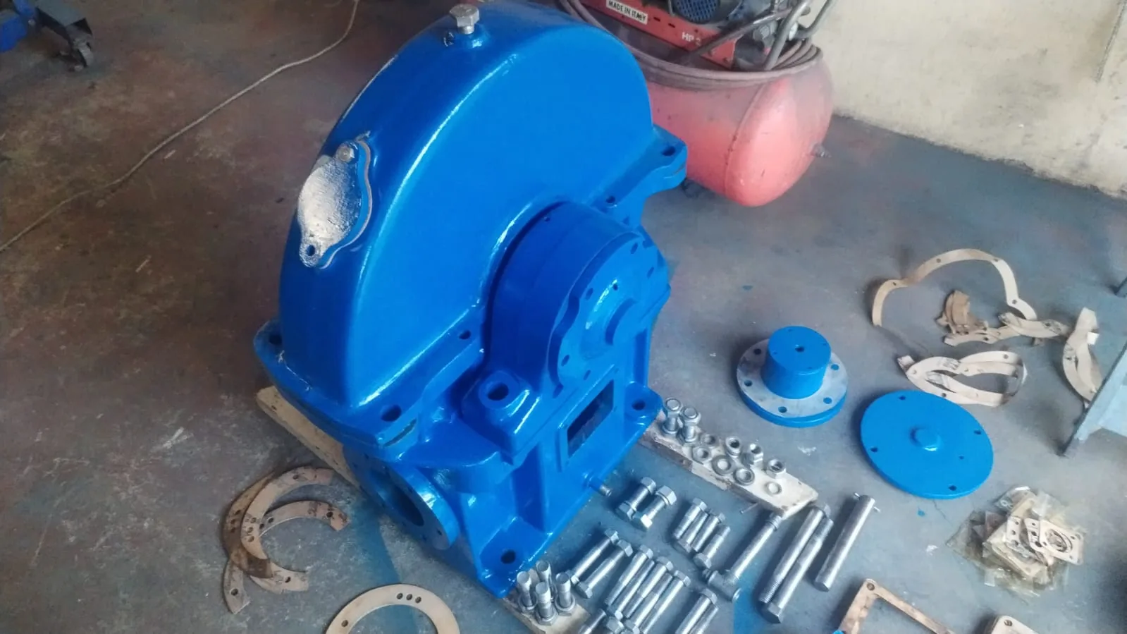Blue lift machine casing and components prepared for workshop assembly.