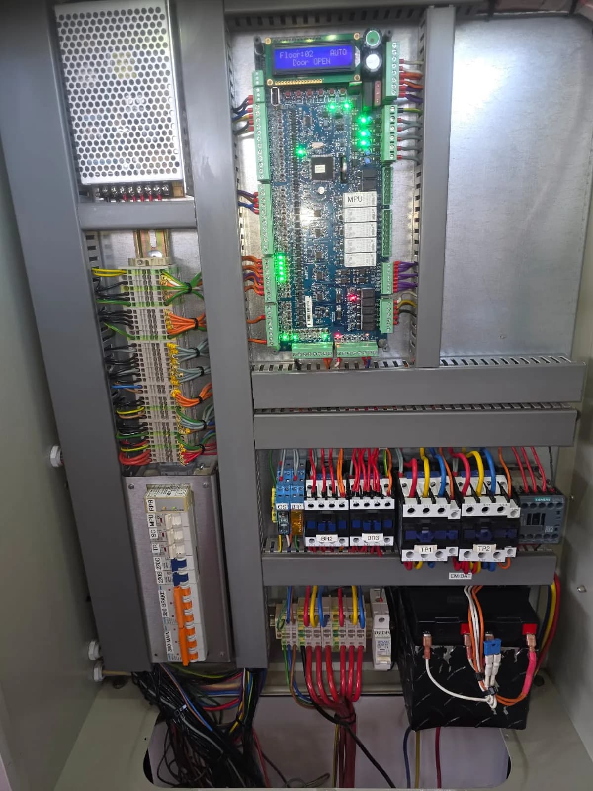 Circuit board, terminals and wiring inside an elevator control panel.